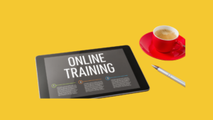 Keltaisella taustalla on tabletti, jossa lukee "Online training", tabletin vieressä on kynä ja punainen kahvikuppi.