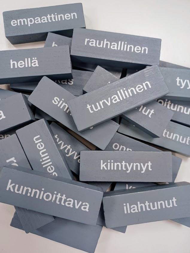 Harmaita palasia, joissa lukee erilaisia tunteita, kuten hellä, rauhallinen, turvallinen, kiintynyt, kunnioittava ja ilahtunut.