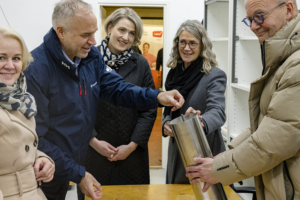 Kirsi Viitala, Markku Hyttinen, Henni Huttu-Hiltunen, Seija Norup ja Ari-Pekka Anttila ovat pöydän ääressä ja sulkevat metallista aikakapselia.