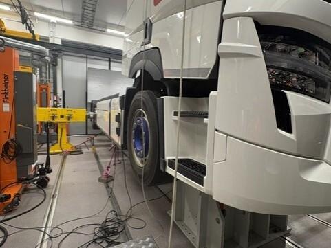 Sähkökuorma-auto ja testilaitteita laboratoriossa.